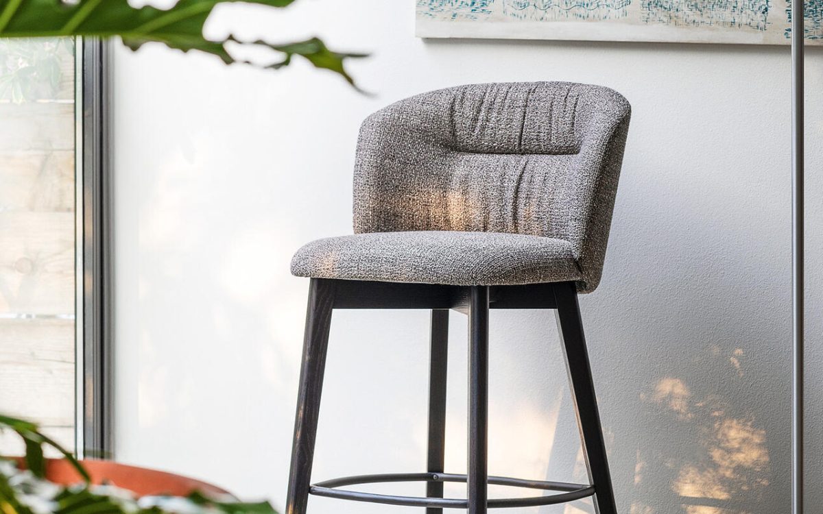 Ιταλικό σκαμπό μπαρ Sweel Wood της Calligaris με βάση gas lift και αγκαλιαστή πλάτη, διαθέσιμο με υφασμάτινη ή δερμάτινη επένδυση.