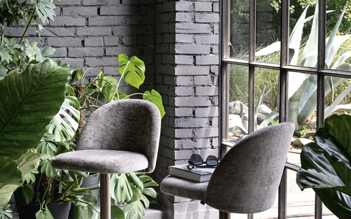 Ιταλικό σκαμπό μπαρ Tuka Mid Lift της Connubia με επενδεδυμένο κέλυφος και ρύθμιση ύψους gas-lift, ταιριάζει σε πάγκο κουζίνας ή νησίδα.